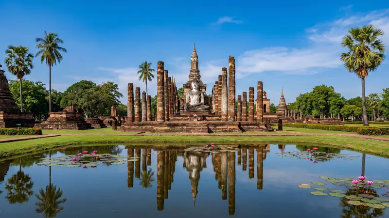 Wat Mahathat in Sukhothai Historical Park, reflected in a lotus pond